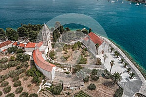 Aerial drone shot of St. Jeronima church with stone tower on Vis Island port in Croatia summer photo