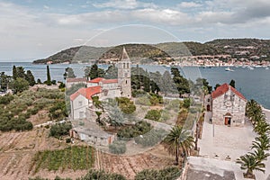 Aerial drone shot of St. Jeronima church on Vis Island coastline by adriatic sea in summer photo