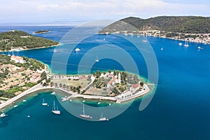 Aerial drone shot of St. Jeronima church on Vis Island coastline by adriatic sea in summer photo