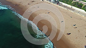 Aerial drone shot surfer skimboarding in sea beach Estoril Portugal