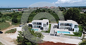 Aerial drone shot of two identical vacation homes or villas with sea view.