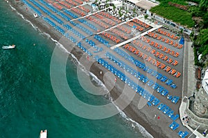 Aerial drone shot view of Positano village and beach with beach umbrella in the morning in Amalfi Coast