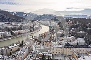 Aerial drone shot view of Salzburg Monchsberg Salzach river and Hohensalzburg fortress Untersberg snow mountain