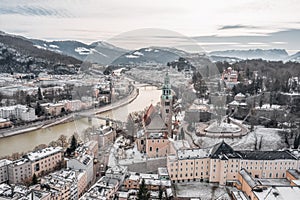 Aerial drone shot view of Salzburg Monchsberg Salzach river and Hohensalzburg fortress Untersberg snow mountain