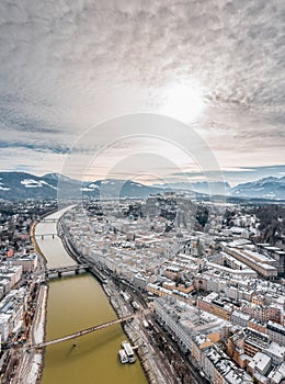 Aerial drone shot view of Salzburg Salzach river and Hohensalzburg fortress Untersberg snow mountain