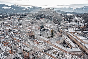 Aerial drone shot view of snowy salzburg city center with view of Cathdrals and fortress in winter photo