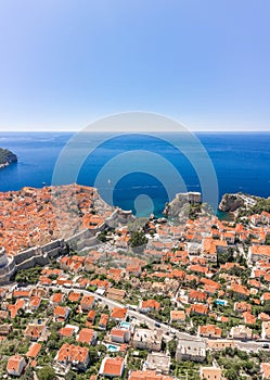 Aerial drone shot of West city wall of Dubrovnik old town by Adriatic sea in Croatia summer noon