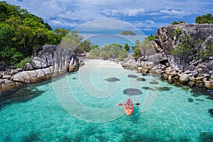 Aerial top view of man kayaking in crystal clear lagoon sea water near Koh Kra island in Thailand photo
