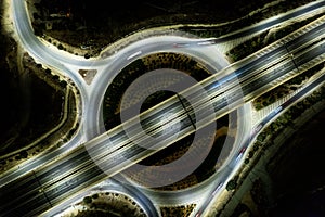Aerial drone top view of a modern motorway junction roundabout with cars moving. Transportation infrastructure,