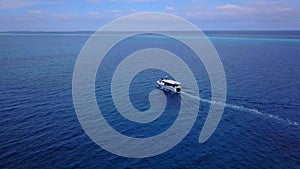 Aerial drone tracking video of luxury yacht cruising in deep blue open ocean sea. Tropical. Atlantic ocean. Between