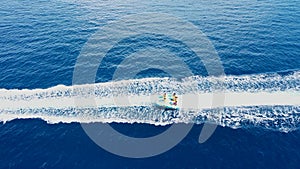 Aerial drone video of extreme powerboat donut water-sports cruising in high speed in tropical emerald crystal clear bay