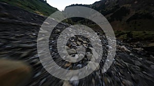 Aerial drone video of flying over a rocky mountain waterfall river at Cirque de Gavarnie.