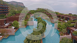 Aerial drone video footage of the hotel courtyard. Vacation at the resort. Green shrubs. Mountains in the background