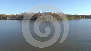 Aerial drone video panning very slowly from right to left over the calm water of the river in Rosemere with an island as point of