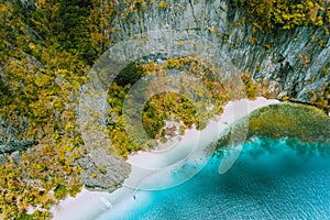 Aerial drone view of abandoned house hut on Pinagbuyutan Island in El Nido. Amazing white sand beach and emerald lagoon