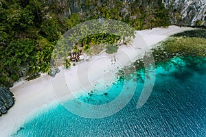 Aerial drone view of abandoned house hut on Pinagbuyutan Island in El Nido. Amazing white sand beach and emerald lagoon