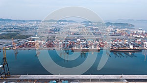 Aerial drone view above dockyard. Cargo vessel is loading containers.