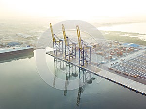 Aerial drone view above dockyard. Scenic view of cargo industrial commercial port in dawn.