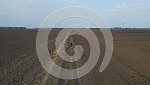 Aerial drone view from above of family ride on bikes outdoors on the spring field