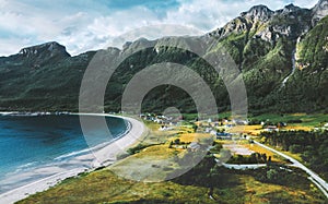 Aerial drone view above Storvika beach and ocean with mountains above village landscape