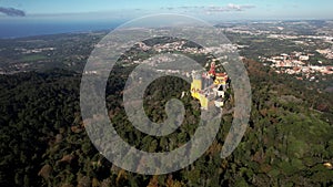 Aerial drone view approaching Pena Palace, a romanticist castle in the Sintra mountains of Portugal 25km west of Lisbon