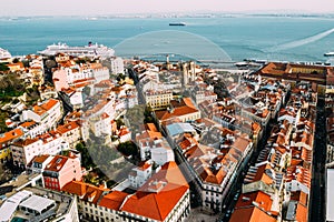 Aerial drone view of Baixa district in Lisbon, Portugal with surrounding major landmarks including Se Cathedral and cruise ship