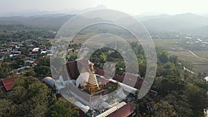 Aerial drone view of beautiful golden pagoda at Wat Phra That Cho Hae Temple in Phrae province, Thailand.