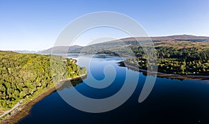 Aerial drone view of a beautiful, tranquil Scottish loch in the early morning sunshine Loch Eil, Fort William