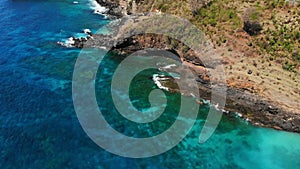 Aerial drone view of blue ocean, rocks with stones