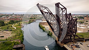 Aerial drone view of a boat sailing on the Chicago river under a bridge