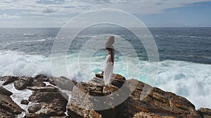 Aerial Drone View of Bride in an Amazing Dress on a Cliff at the Sea