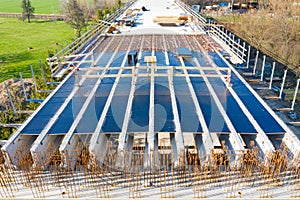 Aerial drone view on the bridge during construction. Concrete layer with material from above