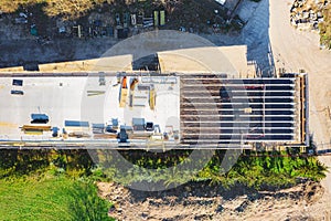 Aerial drone view on the bridge during construction. Concrete layer with material from above