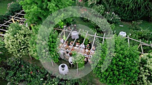 Aerial drone view captures the serene elegance of a summer wedding dinner held outdoors.