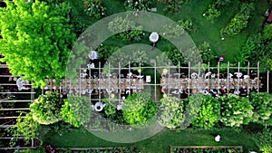 Aerial drone view captures the serene elegance of a summer wedding dinner held outdoors.