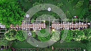 Aerial drone view captures the serene elegance of a summer wedding dinner held outdoors.