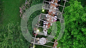 Aerial drone view captures the serene elegance of a summer wedding dinner held outdoors.