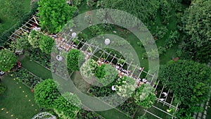 Aerial drone view captures the serene elegance of a summer wedding dinner held outdoors.