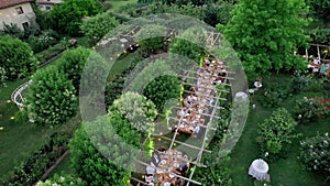 Aerial drone view captures the serene elegance of a summer wedding dinner held outdoors.