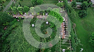Aerial drone view captures the serene elegance of a summer wedding dinner held outdoors.