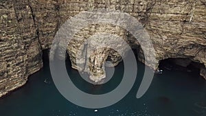 Aerial drone view of caves under a Slave cliff or Traelanipan, Faroe Islands.