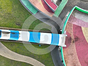 Aerial drone view children playground in the form of a puzzle piece. Colorfull recreation area with slide, swing and