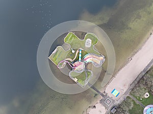 Aerial drone view children playground in the form of a puzzle piece. Colorfull recreation area with slide, swing and