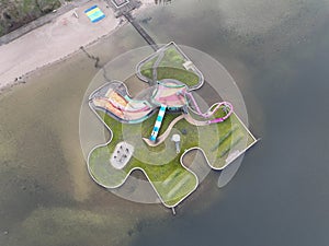 Aerial drone view children playground in the form of a puzzle piece. Colorfull recreation area with slide, swing and