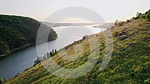 Aerial drone view on cliff mountain shores, covered with forest. Beautiful summer nature of earth. Amazing background