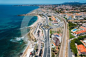 Aerial drone view of coastline hugging the Marginal Avenue with Sao Pedro de Estoril district in Greater Lisbon, Portugal