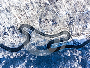 Aerial drone view of a curved winding road through the forest hi