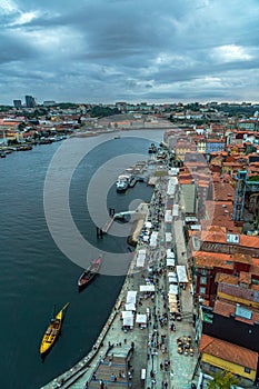 Aerial drone view of the Douro river and the Porto seafront with the old houses, and classic boats at the dock restaurants and