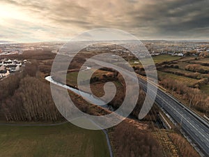 Aerial drone view on empty M6 road at sunset. Galway city, Ireland. Cloudy sky, fog over some areas of town