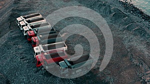 Aerial drone view of excavator and dump trucksin construction site by the sea side. Construction industry